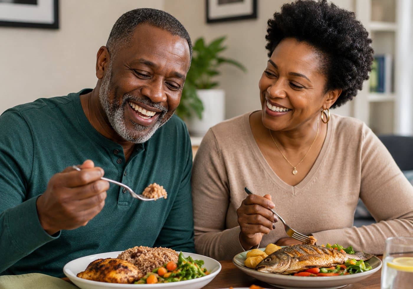 An older couple laughing together over a meal of grilled chicken, brown rice, fish and vegetables
